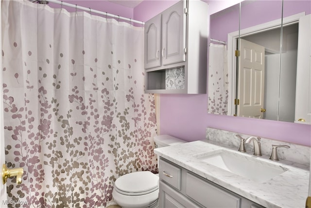 bathroom with vanity, toilet, and curtained shower