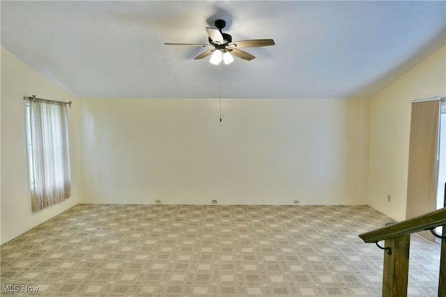 carpeted empty room featuring vaulted ceiling and ceiling fan