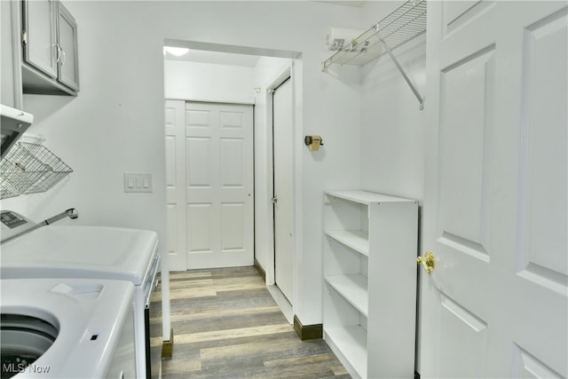 washroom featuring wood-type flooring, cabinets, and separate washer and dryer