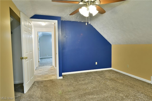 additional living space featuring a textured ceiling, vaulted ceiling, carpet floors, and ceiling fan