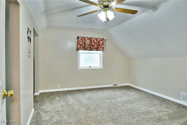 bonus room with carpet, a textured ceiling, lofted ceiling, and ceiling fan