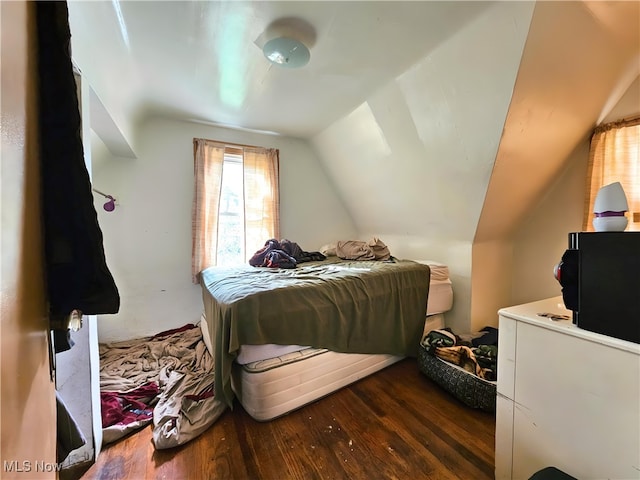 bedroom with lofted ceiling and dark hardwood / wood-style floors