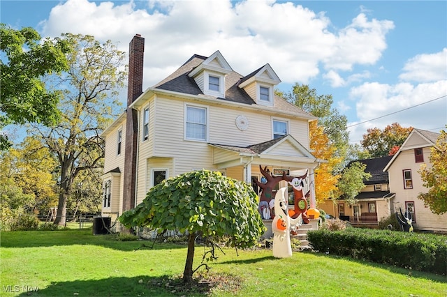 view of front of property featuring a front yard and central AC unit