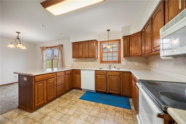 kitchen with sink, kitchen peninsula, hanging light fixtures, and white appliances