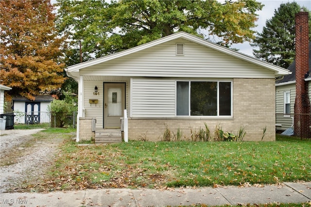 bungalow with a front yard and a storage unit