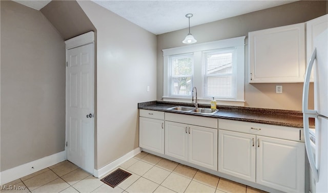 kitchen featuring white cabinets, light tile patterned flooring, pendant lighting, sink, and white refrigerator