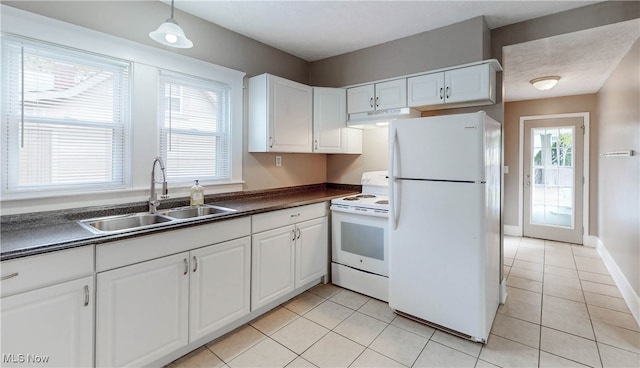 kitchen with hanging light fixtures, sink, light tile patterned floors, white cabinets, and white appliances