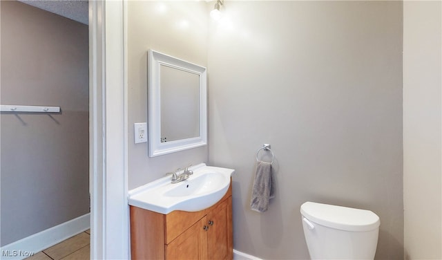 bathroom with vanity, toilet, and tile patterned floors