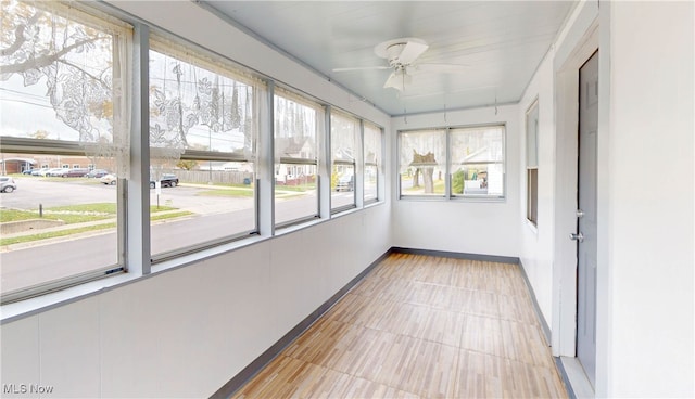 unfurnished sunroom with a healthy amount of sunlight and ceiling fan