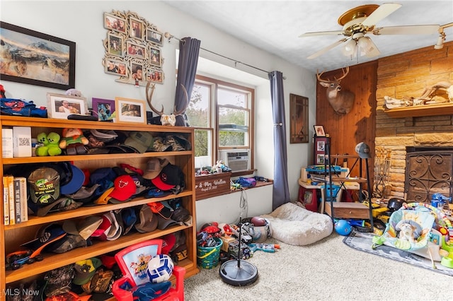 interior space featuring wooden walls, cooling unit, carpet flooring, and ceiling fan