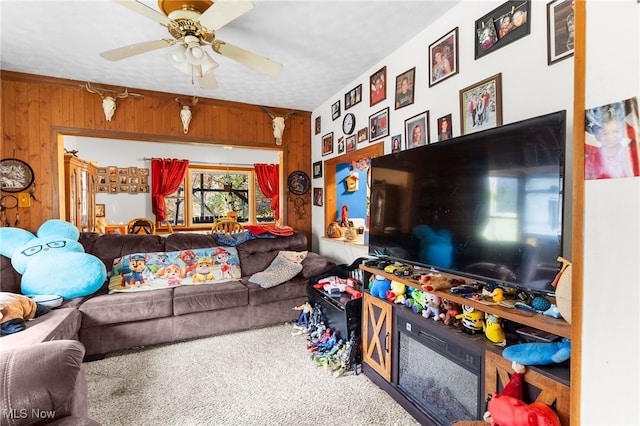 living room with wooden walls, carpet flooring, and ceiling fan