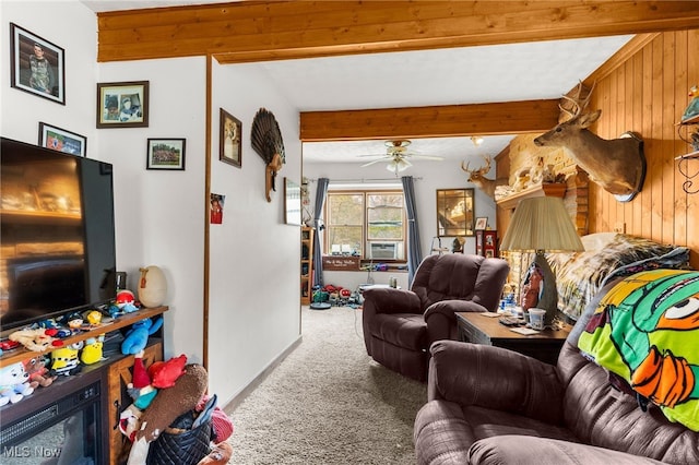 living room featuring beamed ceiling, ceiling fan, carpet flooring, and wood walls