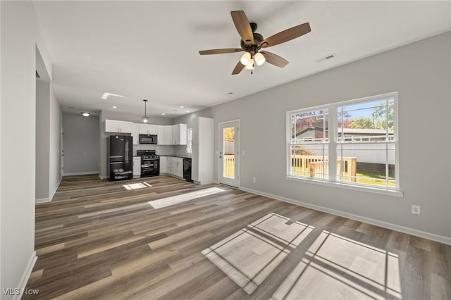 unfurnished living room featuring ceiling fan and hardwood / wood-style floors