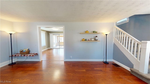 interior space featuring a textured ceiling and wood-type flooring