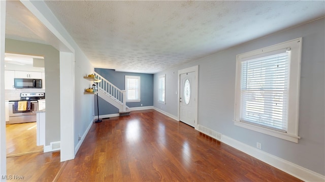 foyer featuring hardwood / wood-style floors and a textured ceiling