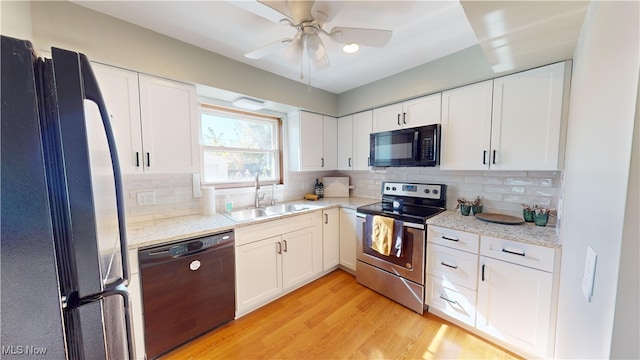 kitchen featuring backsplash, sink, black appliances, white cabinetry, and light hardwood / wood-style floors