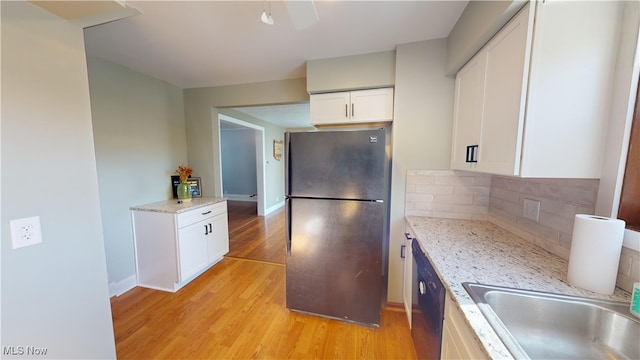 kitchen with white cabinets, light stone countertops, light hardwood / wood-style flooring, sink, and stainless steel appliances