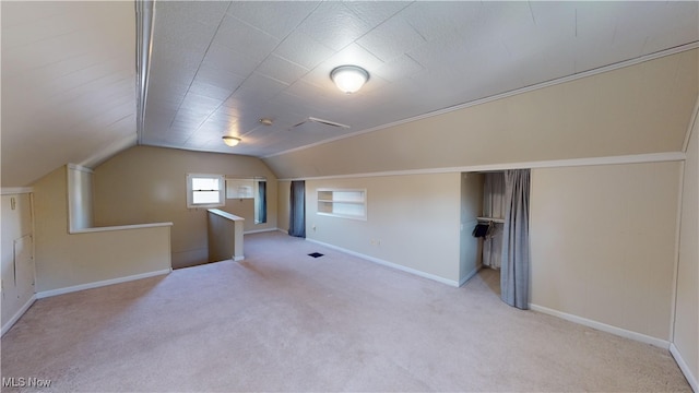 bonus room with vaulted ceiling and light carpet