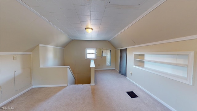 additional living space featuring light carpet, built in features, and vaulted ceiling