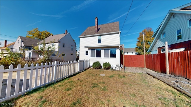 rear view of property featuring a lawn