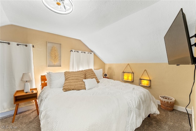 bedroom with a textured ceiling, carpet, and vaulted ceiling