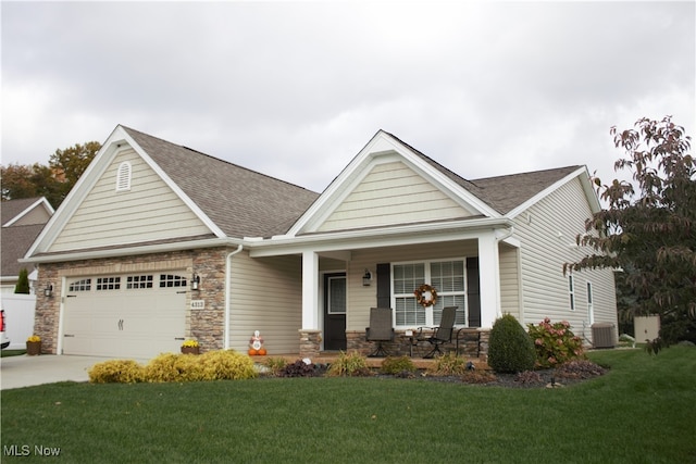 craftsman-style house with a front yard, a garage, and covered porch