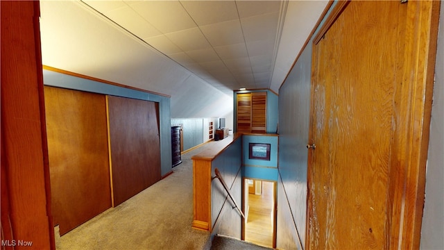 corridor with light carpet and vaulted ceiling