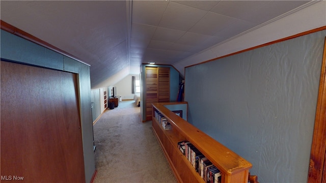 corridor with vaulted ceiling and light colored carpet