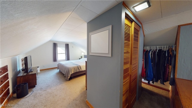 bedroom featuring carpet, vaulted ceiling, and a textured ceiling