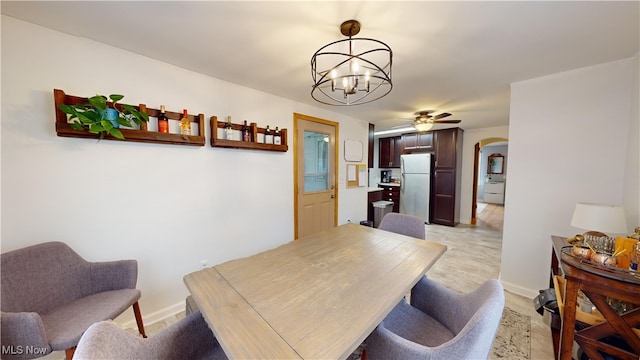 dining area with ceiling fan with notable chandelier