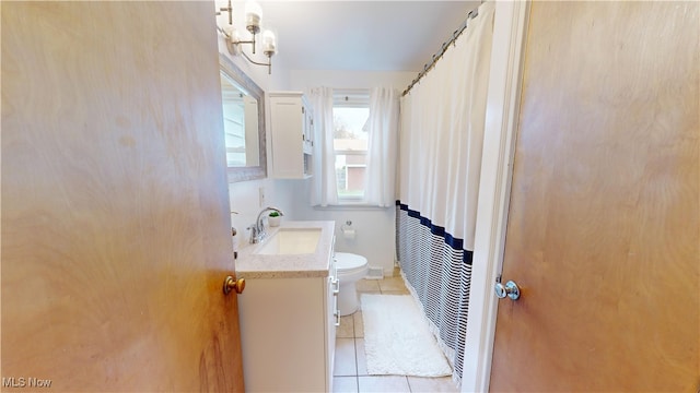 bathroom with toilet, curtained shower, vanity, and tile patterned flooring