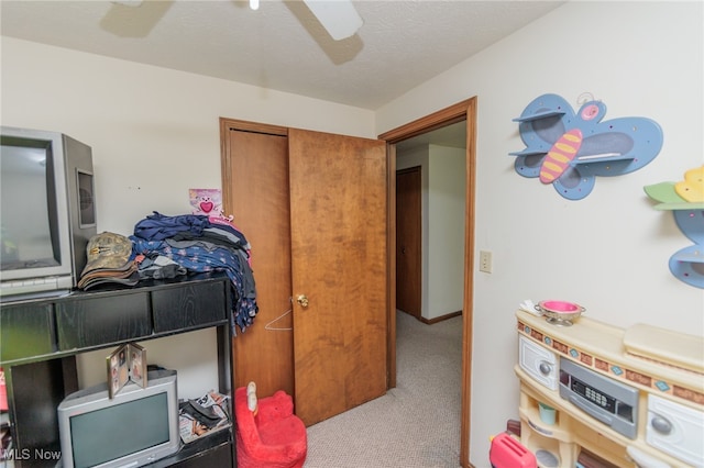 bedroom featuring a closet, ceiling fan, carpet, and a textured ceiling