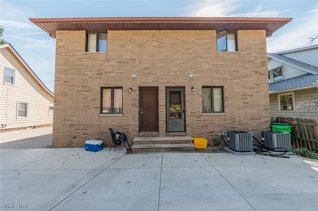 rear view of house with central air condition unit and a patio area