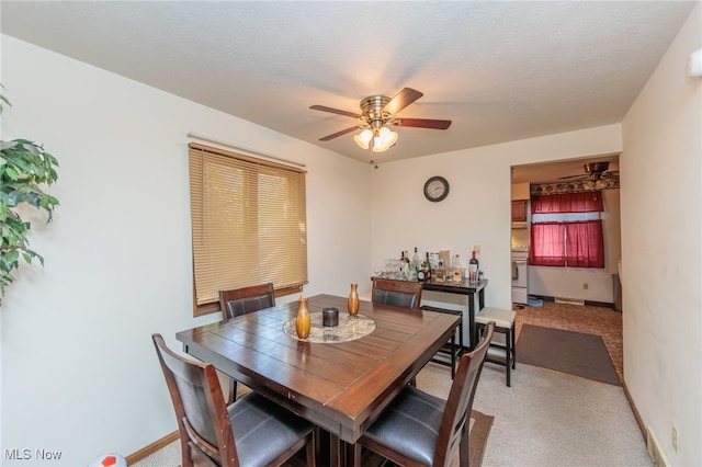 carpeted dining room with ceiling fan and a textured ceiling