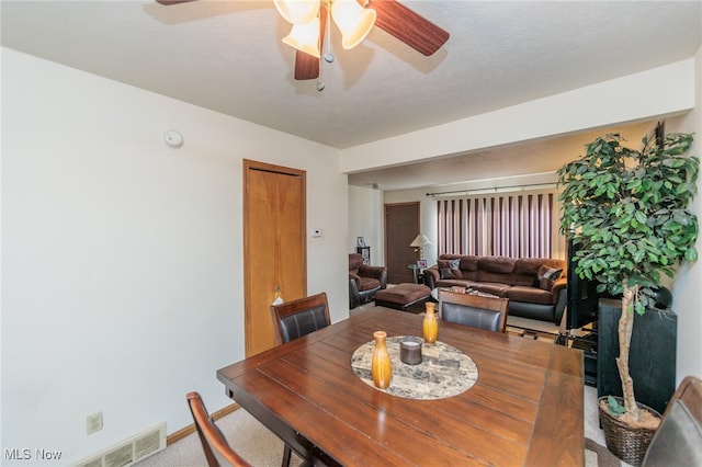 dining area featuring a textured ceiling, carpet, and ceiling fan