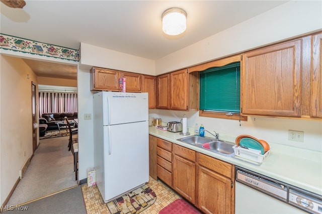 kitchen with sink, light colored carpet, and white appliances