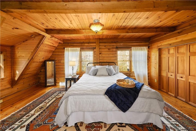 bedroom featuring hardwood / wood-style flooring, lofted ceiling with beams, wooden ceiling, and wooden walls