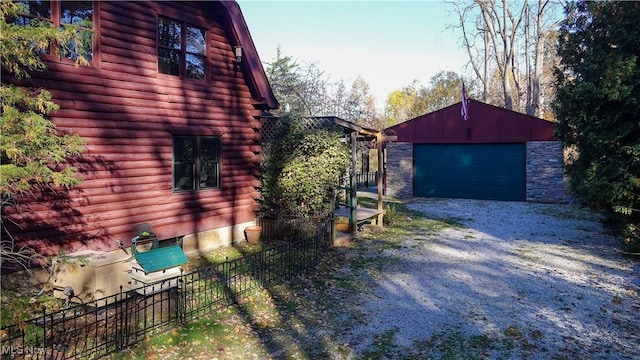 view of side of home with a garage and an outbuilding