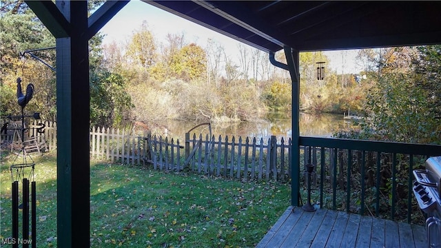 wooden terrace with a yard and a water view