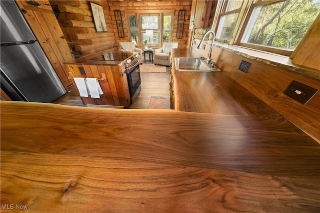 kitchen featuring stainless steel fridge, sink, and dark wood-type flooring