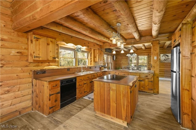 kitchen featuring a healthy amount of sunlight, light hardwood / wood-style flooring, a kitchen island, and black appliances