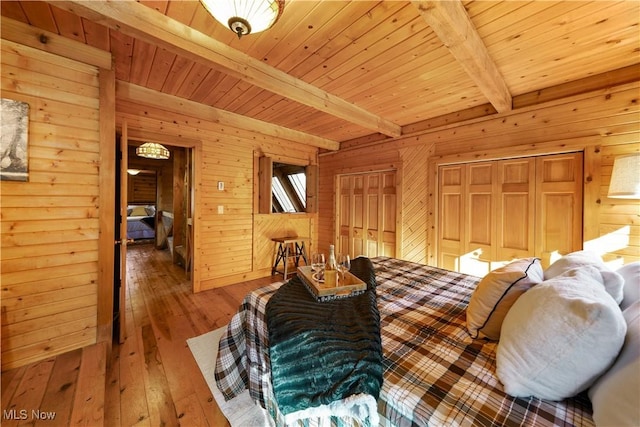 bedroom featuring beamed ceiling, hardwood / wood-style flooring, wood ceiling, and wood walls