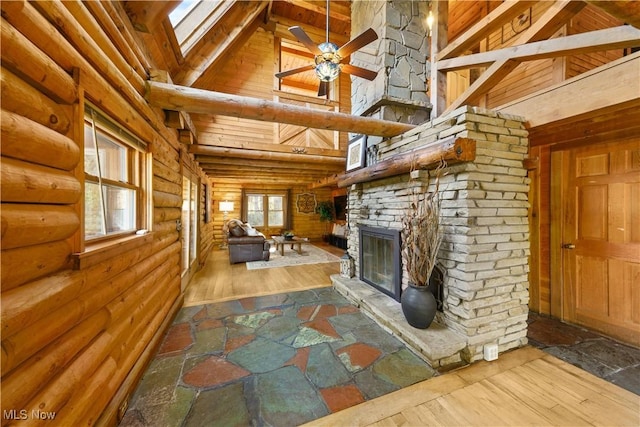 unfurnished living room featuring beam ceiling, a stone fireplace, high vaulted ceiling, and wood-type flooring