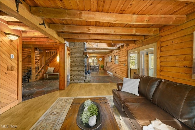 living room with beam ceiling, wooden walls, hardwood / wood-style flooring, and wooden ceiling