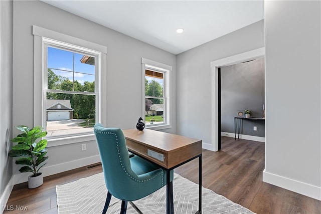 home office with dark hardwood / wood-style floors