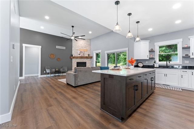 kitchen with dark wood-type flooring, white cabinetry, and a fireplace