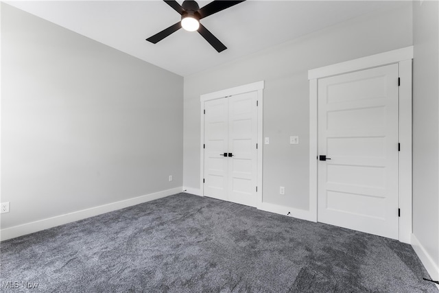 unfurnished bedroom featuring dark carpet and ceiling fan