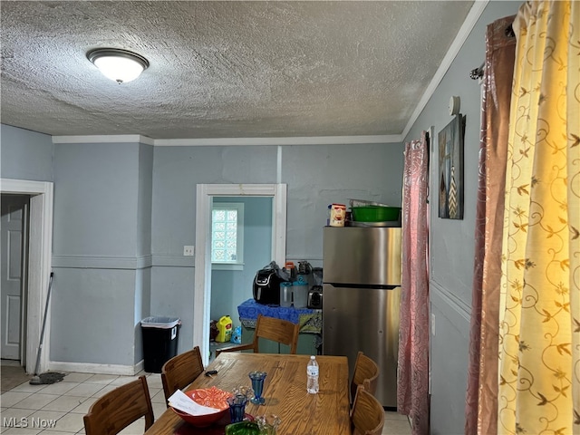 dining area with crown molding, light tile patterned flooring, and a textured ceiling