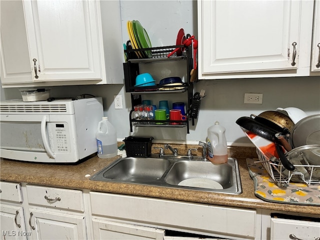 kitchen featuring white cabinets and sink