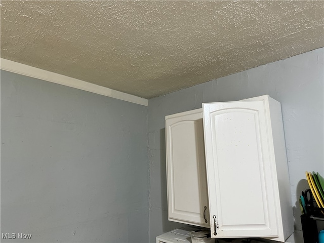 interior details with white cabinets and a textured ceiling